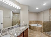 Thumbnail 12 of 27 - A bathroom with a double sink vanity and a bathtub.