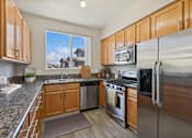 Thumbnail 2 of 23 - a kitchen with stainless steel appliances and wooden cabinets