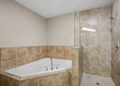 Thumbnail 13 of 27 - A bathroom with a tiled shower and a white sink.