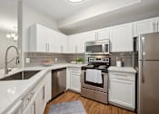 Thumbnail 2 of 20 - a kitchen with stainless steel appliances and white cabinets