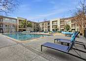 Thumbnail 19 of 42 - A swimming pool surrounded by a concrete floor and a bench with a blue cover.