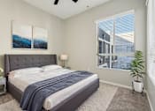Thumbnail 7 of 28 - A bedroom with a large bed and a ceiling fan.