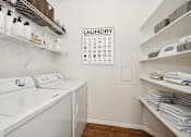 Thumbnail 9 of 20 - a laundry room with a washer and dryer and a calendar on the wall