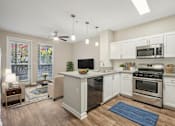 Thumbnail 3 of 28 - A kitchen with white cabinets and a blue rug on the floor.