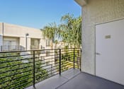 Thumbnail 13 of 28 - A balcony with a white door and a black railing.