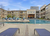 Thumbnail 36 of 42 - A swimming pool surrounded by a building and a bench.