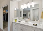 Thumbnail 6 of 22 - a bathroom with a sink and a mirror and a closet