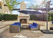 Thumbnail 20 of 24 - A patio with a fireplace and chairs.