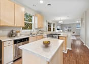 Thumbnail 1 of 16 - a large kitchen with an island with a bowl of fruit