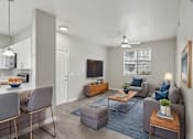 Thumbnail 5 of 28 - A living room with a grey couch, a coffee table, and a television.