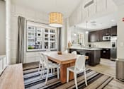 Thumbnail 20 of 27 - A modern kitchen with a dining table and chairs.