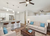 Thumbnail 5 of 28 - A living room with a white couch and a coffee table.