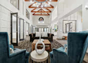 Thumbnail 19 of 27 - A large, modern room with a high ceiling and a mix of dark and light furnishings.