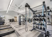 Thumbnail 20 of 31 - A gym with treadmills, weights, and exercise equipment.
