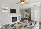 Thumbnail 3 of 23 - an open living room with a fireplace and a ceiling fan