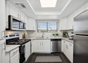Thumbnail 1 of 33 - a kitchen with white cabinets and stainless steel appliances