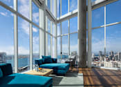 Thumbnail 19 of 33 - A living room with a view of the cityscape.