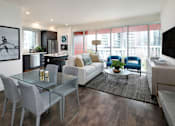 Thumbnail 17 of 33 - A modern living room with a glass table and grey chairs.