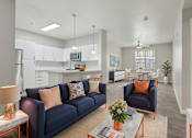 Thumbnail 6 of 28 - A living room with a blue couch and a coffee table.