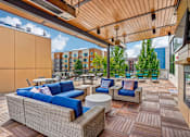 Thumbnail 27 of 31 - A patio with blue couches and a wooden floor.