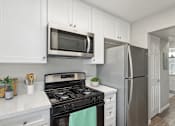 Thumbnail 1 of 22 - a kitchen with stainless steel appliances and white cabinets