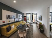 Thumbnail 4 of 29 - a living room with a yellow couch and a black wall and a balcony