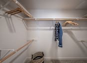 Thumbnail 11 of 28 - a walk in closet with a rack of clothes and a basket on the floor