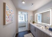 Thumbnail 5 of 28 - a bathroom with a sink and a mirror and a door to a bedroom