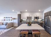 Thumbnail 1 of 28 - a kitchen with stainless steel appliances and a white island with four chairs