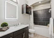 Thumbnail 30 of 42 - A modern bathroom with a white toilet, a white sink, and a white bathtub.
