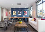 Thumbnail 22 of 24 - a living room with a blue accent wall and a wooden coffee table with a potted plant