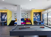 Thumbnail 17 of 24 - a pool table with a colorful couch in the background
