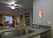 Thumbnail 19 of 20 - A kitchen with a Happy Hour Club neon sign.