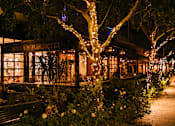 Thumbnail 26 of 26 - A restaurant named Buona Ferretti is lit up at night with lights and decorations.