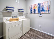Thumbnail 9 of 31 - a washer and dryer in a laundry room with a painting on the wall