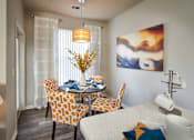 Thumbnail 4 of 31 - a dining room with a table and chairs and a painting on the wall