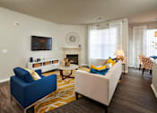 Thumbnail 3 of 31 - a living room with a couch and a chair and a television