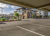Thumbnail 19 of 21 - A parking lot with a building in the background.