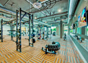 Thumbnail 8 of 29 - A gym with a variety of equipment including weight machines and free weights.