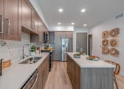 Thumbnail 1 of 24 - A kitchen with wooden cabinets and a white countertop.