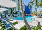 Thumbnail 9 of 24 - A pool area with lounge chairs and umbrellas.