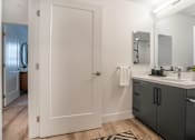 Thumbnail 7 of 25 - a bathroom with a sink and a mirror and a closet