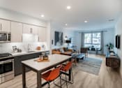 Thumbnail 2 of 25 - a living room with a kitchen and a dining table