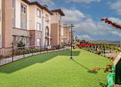 Thumbnail 16 of 21 - A building with a green lawn in front of it.