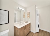 Thumbnail 7 of 30 - a bathroom with a sink and a mirror and washer/dryer