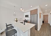 Thumbnail 1 of 30 - a kitchen with a large island and a stainless steel refrigerator