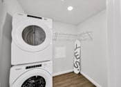 Thumbnail 8 of 30 - a white laundry room with a washer and dryer and a surfboard in