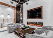 Thumbnail 14 of 20 - A modern living room with a fireplace and a flat screen TV mounted on the wall.