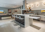 Thumbnail 17 of 25 - A modern kitchen with a bar area and stools.