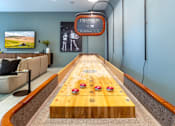 Thumbnail 3 of 25 - A long wooden table with numbered pads and red buttons is in the middle of a room.